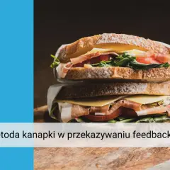 Apetyczna kanapka z szynką, serem i warzywami, symbolizująca metodę kanapki w przekazywaniu feedbacku.