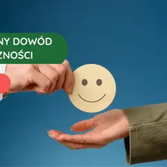 Marketing opiera się na społecznym dowodzie słuszności. Dłoń podaje uśmiechniętą buźkę, symbolizując pozytywne opinie.