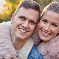 Uśmiechnięta para w jesiennym słońcu. Szukasz pomysłów na randkę z mężem? Spędźcie czas razem na łonie natury!
