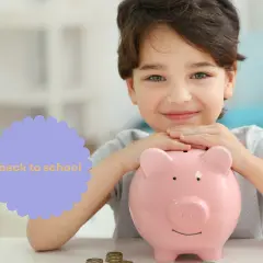 Uśmiechnięty chłopiec z różową świnką-skarbonką, zbiera kieszonkowe dla dziecka na powrót do szkoły.