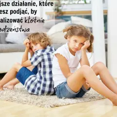 Smutna siostra z bratem siedzą plecami do siebie na dywanie, zamyśleni.