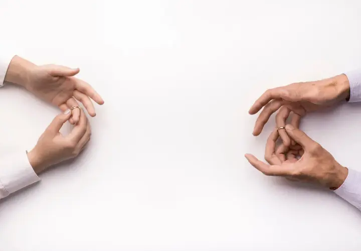 Dłonie zdejmują obrączki, symbolizując konsekwencje unieważnienia małżeństwa kościelnego.