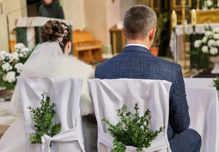 Para młoda siedzi w kościele. Krzesła ozdobione zielonymi gałązkami. Kto nie może być świadkiem na ślubie kościelnym?