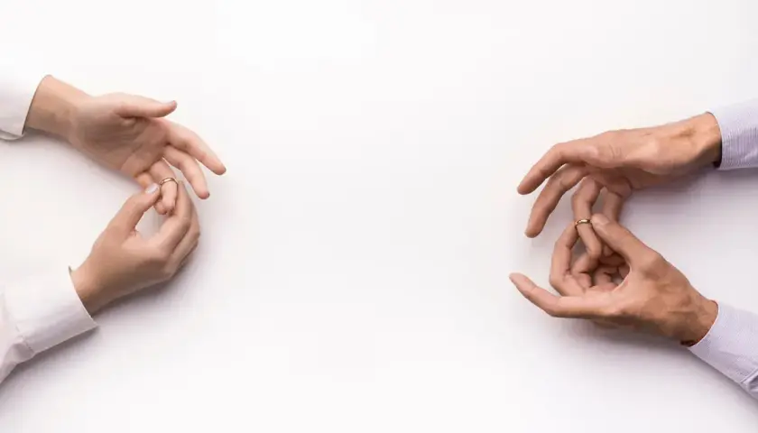 Dłonie zdejmują obrączki, symbolizując konsekwencje unieważnienia małżeństwa kościelnego.