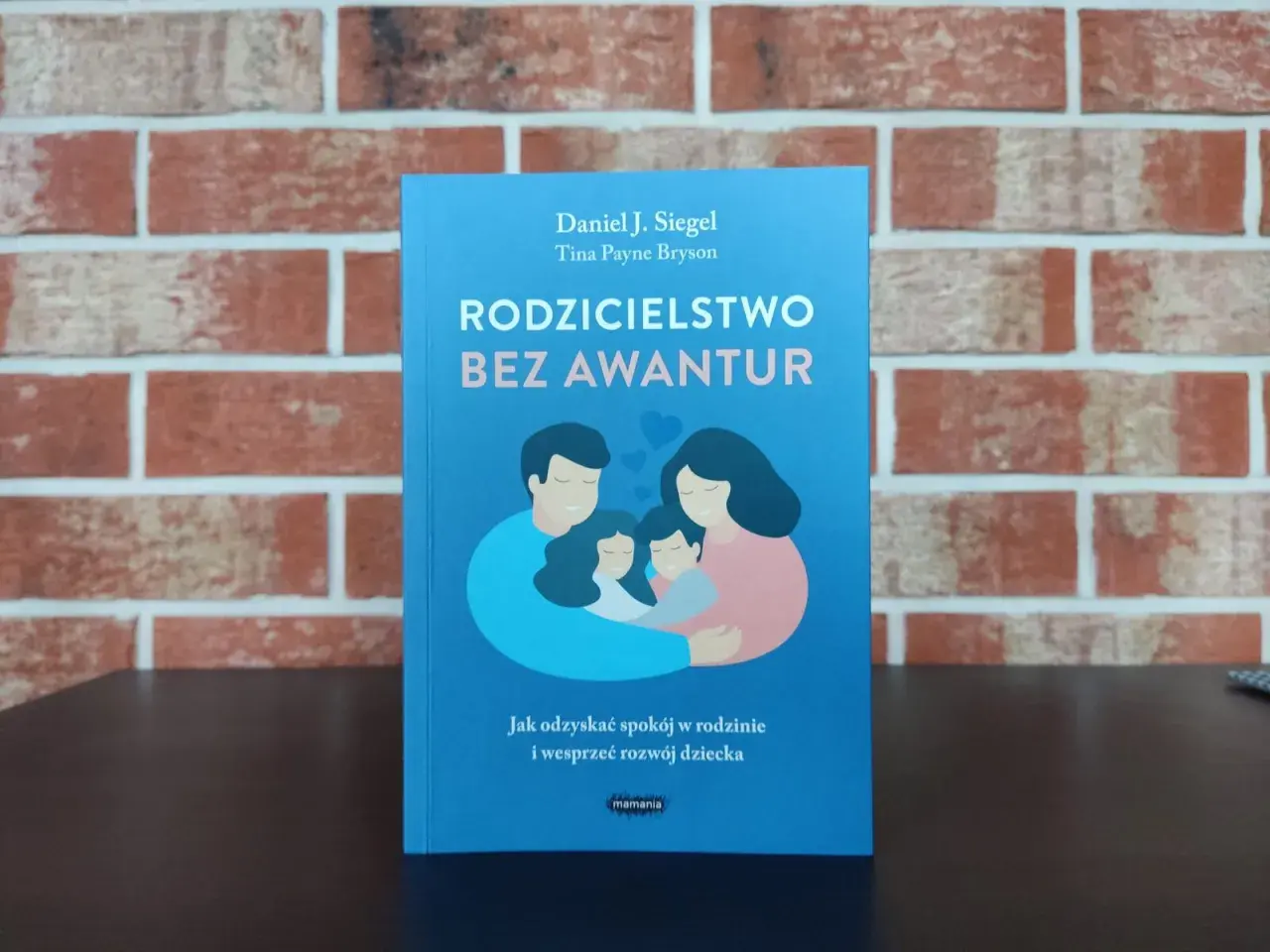 Książka "Rodzicielstwo bez awantur" o budowaniu dobrych relacji w rodzinie. Ilustracja przedstawia przytulającą się rodzinę.