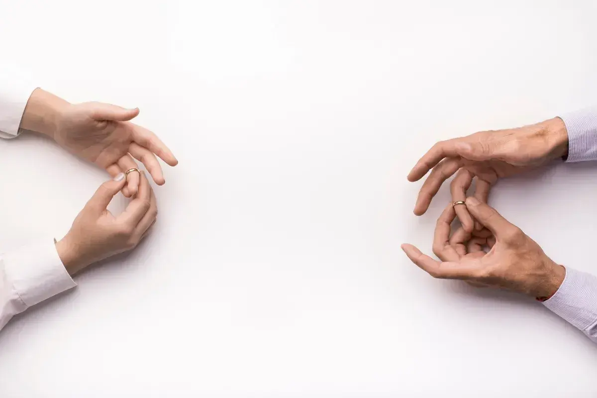 Dłonie zdejmują obrączki, symbolizując konsekwencje unieważnienia małżeństwa kościelnego.