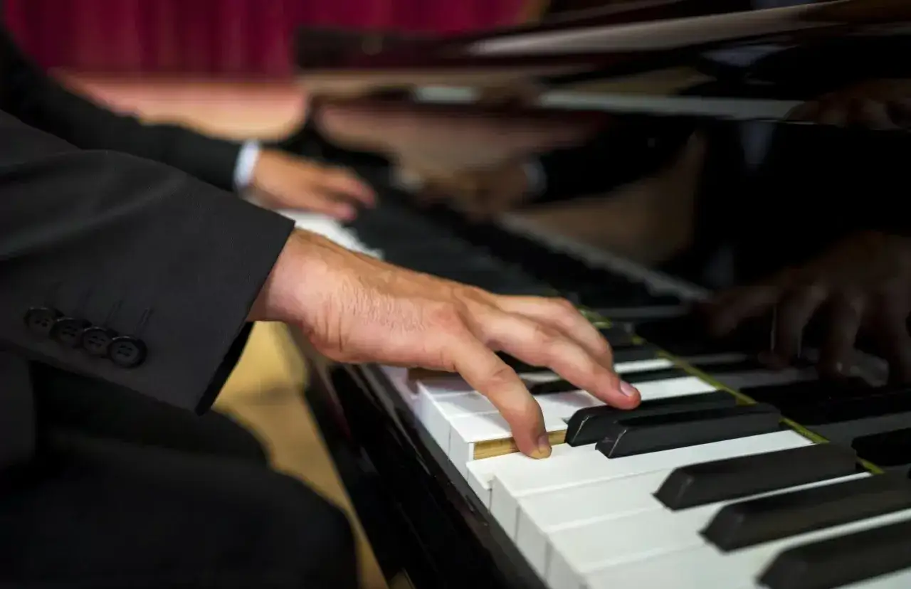Dłoń muzyka grającego na fortepianie. Zastanawiasz się, ile bierze organista za ślub?