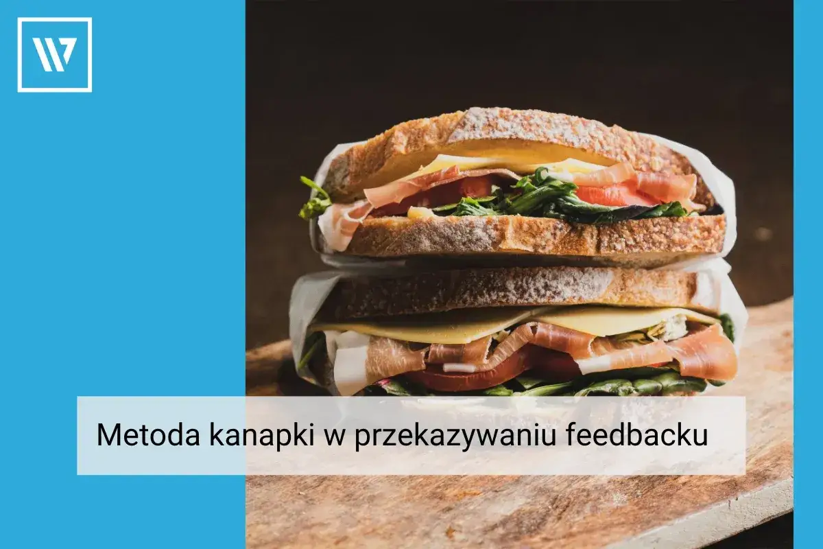 Apetyczna kanapka z szynką, serem i warzywami, symbolizująca metodę kanapki w przekazywaniu feedbacku.
